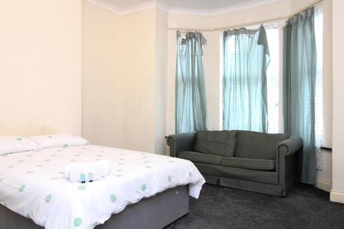 a bedroom with a bed and a chair and a window at Centrally located double rooms in Southampton