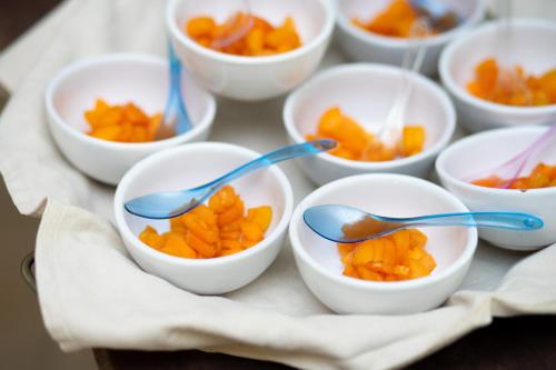 un gruppo di ciotole bianche piene di arance con cucchiai di Villaggio Marco Polo a Santa Domenica