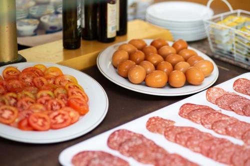 un tavolo con piatti di carne e pomodori sopra di Villaggio Marco Polo a Santa Domenica