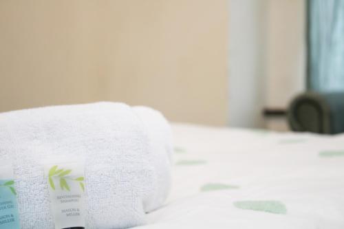 a stack of towels sitting on a bed at Centrally located double rooms in Southampton