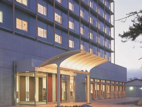 a large building with a canopy in front of it at Ou Hotel in Yonago