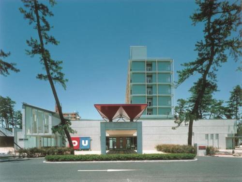 a building with a large building in the background at Ou Hotel in Yonago