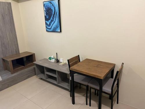 Avida Riala Tower 3 unit 2614 في مدينة سيبو: غرفة طعام بها طاولة وكراسي خشبية