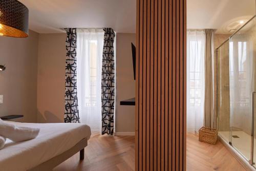 une chambre avec un lit et une douche en verre dans l'établissement Le Filet Suspendu-Expérience-WIFI-CLIM, à Toulon