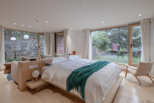 a bedroom with a large bed and a large window at Vretreats Suyunjian Boutique Hotel in Xinglong