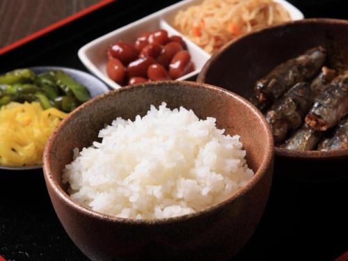 a table with bowls of rice and other foods at Hotel 1-2-3 Kofu Shingen Onsen in Kofu