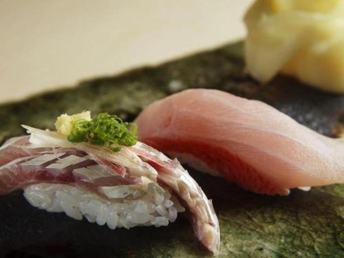 a close up of a piece of sushi and a piece of meat at Nippondaira Hotel in Shizuoka