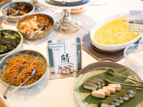 a table with various dishes of food on it at Hotel Harvest In Yonago in Yonago