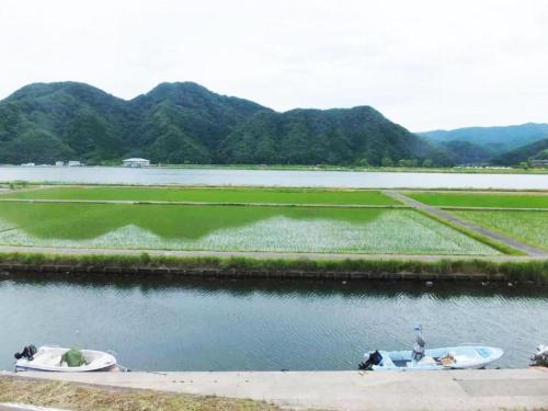 two boats on a river with mountains in the background at Sento Otani Hotel in Toyooka
