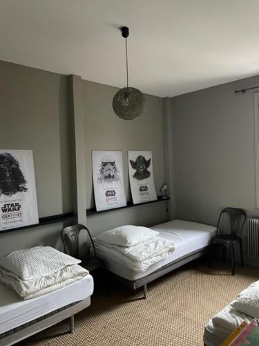 - 2 lits dans une chambre avec des photos sur le mur dans l'établissement La petite Jacqueline, Maison classée 3 étoiles, hyper centre face plage, à Houlgate