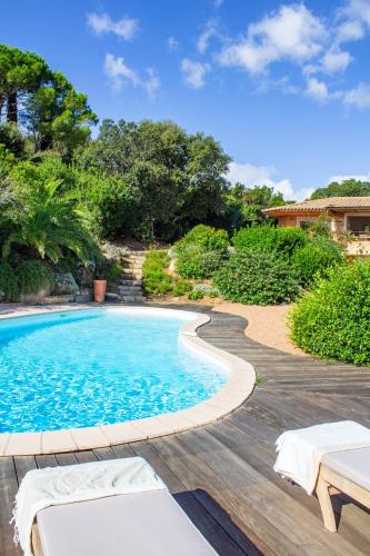 - une piscine dans une cour avec une terrasse en bois dans l'établissement Villa Dolce Vita, à Sainte-Lucie de Porto-Vecchio