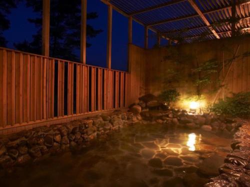 a swimming pool in a backyard at night at Kyoto Keburikawa Hotel in Kameoka