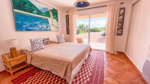 une chambre avec un lit et une grande fenêtre dans l'établissement Villa Dolce Vita, à Sainte-Lucie de Porto-Vecchio