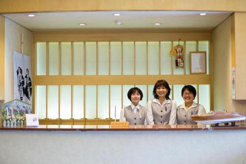 three women are standing behind a counter in a kitchen at Hotel Tango Kingdom in Kyotango