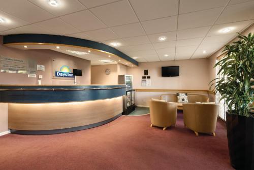 a lobby with a bar and chairs in a hospital at Days Inn Hotel Bradford - Leeds in Brighouse