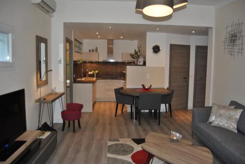 un salon avec un canapé et une table et une cuisine dans l'établissement Le Calme au Centre Ville à 10 minutes à pied de la Croisette et des plages, à Cannes