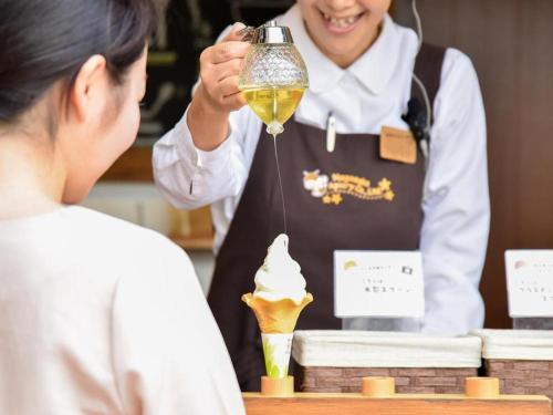 a woman holding up a blender with an ice cream cone at Hamanako Lake Side Plaza in Hamamatsu