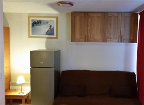 - un salon avec un réfrigérateur et un canapé dans l'établissement Superdévoluy Superbe appartement 6 places avec parking, à Saint-Étienne-en-Dévoluy