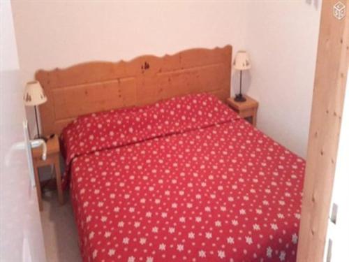 - une chambre dotée d'un couvre-lit rouge avec des points de polka blancs dans l'établissement Superdévoluy Superbe appartement 6 places avec parking, à Saint-Étienne-en-Dévoluy