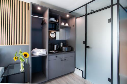 a small kitchen with a sink and a glass door at BeeVillage Messehotel Hannover Laatzen in Hannover
