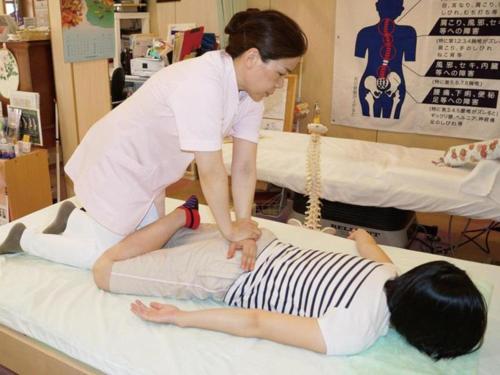 a woman in a hospital examining a patient at Hadano Yugawara Onsen Manyo no Yu in Hadano