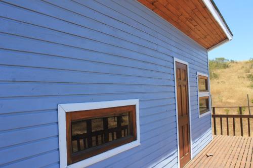 a blue house with a window on a deck at Casa San Juan in San Juan