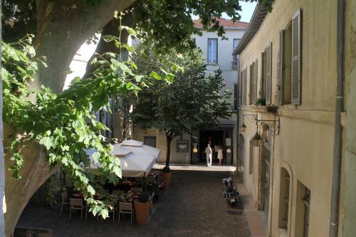 un callejón en una ciudad con gente caminando por la calle en Studios entre le Pont d' Avignon et le Palais des Papes, en Aviñón