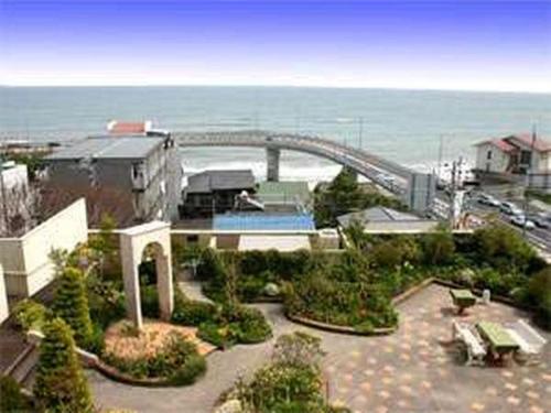 a building with a view of a bridge and the ocean at Hotel Tenchikaku in Hitachi