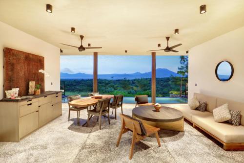 a kitchen and living room with a table and a couch at MAUA Nusa Penida Bali in Nusa Penida