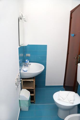 a blue bathroom with a sink and a toilet at Kaary Bella Vista in Marina di Ragusa