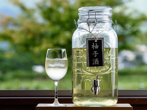 a jar of white wine next to a glass at Yufuin Matousou in Yufuin