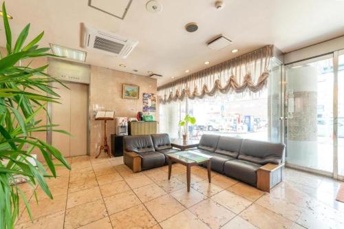 a living room with a couch and a table at Business Hotel Nishiura Yokkaichi in Yokkaichi