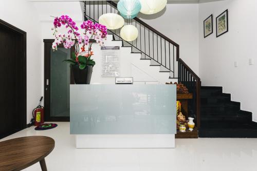 a room with a staircase with a vase of flowers at Le Petit Villa Hoi An in Hoi An