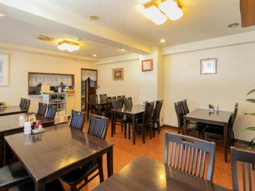 ein Speisesaal mit Tischen und Stühlen in einem Restaurant in der Unterkunft Business Hotel Shinkawa Ube in Ube