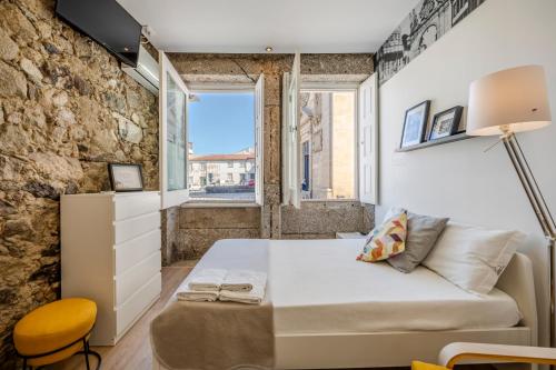 a small bedroom with a bed and a window at SÃO VICTOR Studios HISTORIC CENTER in Braga