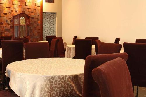 a dining room with tables and chairs and a room with tables and chairs at Tabist Sunshine Koga in Koga