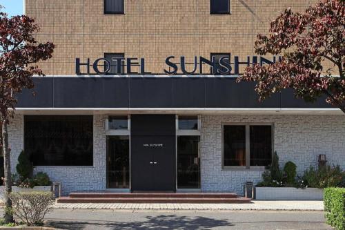 a building with a hotel sunlin sign on it at Tabist Sunshine Koga in Koga
