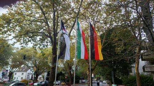 a group of flags on a pole on a street at die Villa, Zimmer 26, DZ in Leverkusen