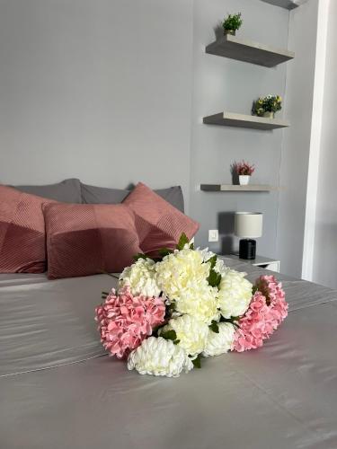 a bouquet of flowers sitting on top of a bed at Dimitris Family Apartment in Nea Moudania