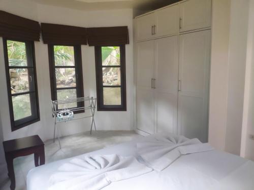 a bedroom with a white bed and some windows at Samui Green Life in Bophut 