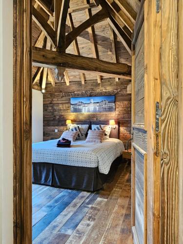 une chambre avec un lit dans une pièce aux murs en bois dans l'établissement Gîte du Château du Clos Voucheot, grand spa de nage, à La Bussière-sur-Ouche