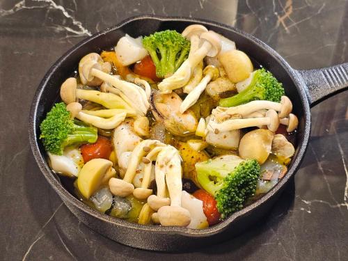 a pan full of food with broccoli and mushrooms at GRAND VERDE RESORT in Kamegawa