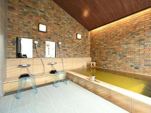 a pool of water in a room with a tub at Kosugi Resort in Aso