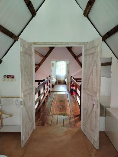 a room with an open door in a attic at Le refuge du pêcheur in Tambe