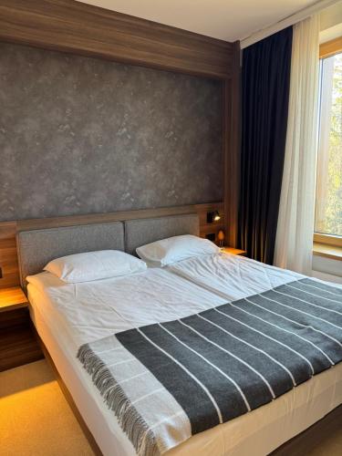 a bedroom with a large bed with a large headboard at Woodside Apartment 431, Kopaonik - One separate bedroom 35m2- FREE Parking & SPA in Kopaonik