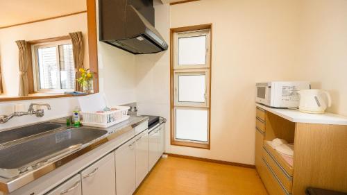 a kitchen with a sink and a microwave at セイントY saint-Y in Motobu