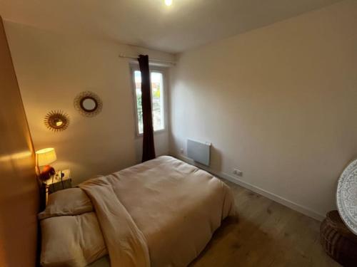a bedroom with a large bed and a window at Chez Manon - Le Cocon Zen in Rumilly