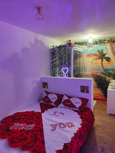 une chambre avec un lit avec des oreillers rouges et blancs dans l'établissement Le romantique, à Argelès-sur-Mer