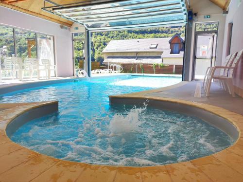 a swimming pool with a fountain in the middle at Résidence Val de Roland in Luz-Saint-Sauveur