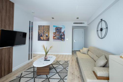 a living room with a couch and a tv at Euphrates Hotel Bursa in İhsaniye